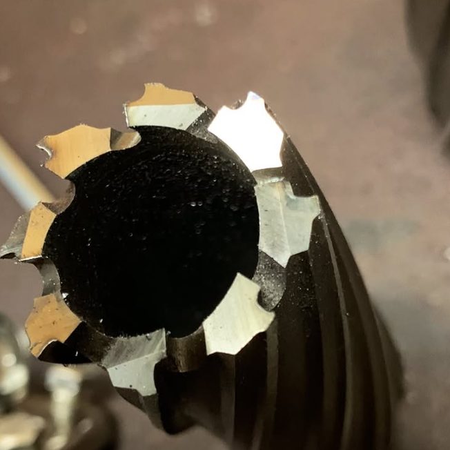 Close-up of a freshly sharpened annular cutter, cutting teeth bright against the black flutes
