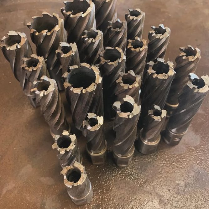 A batch of around twenty annular cutters sharpened and stood on end