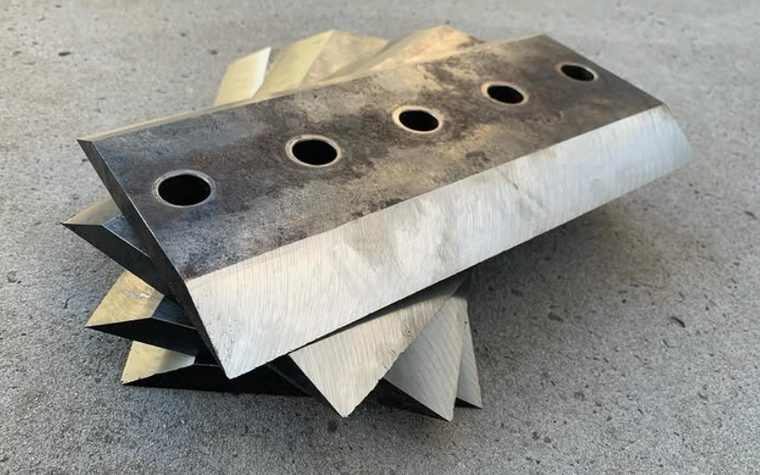 A stack of chipper blades with freshly ground bevels